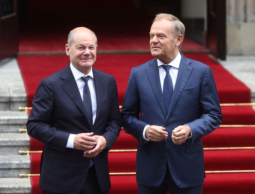 German Chancellor Olaf Scholz and Polish Prime Minister Donald Tusk react on the day of German-Polish inter-governmental consultations in front of Prime Minister Chancellery in Warsaw, Poland July 2, 2024. REUTERS/Lukasz Glowala