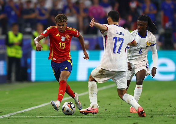 Soccer Football - Euro 2024 - Semi Final - Spain v France - Munich Football Arena, Munich, Germany - July 9, 2024 Spain's Lamine Yamal in action with France's William Saliba and Eduardo Camavinga REUTERS/Leonhard Simon