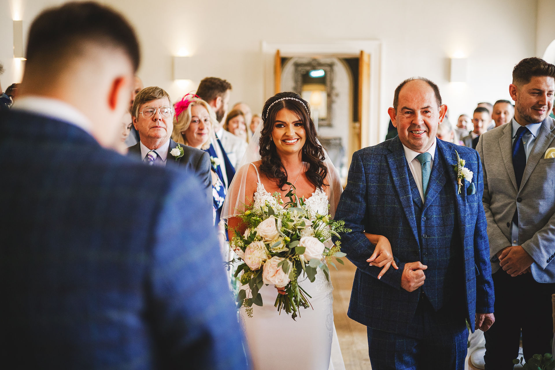 Bride walks down the aisle, smiling with her father; Jon & Anna's Big Day
