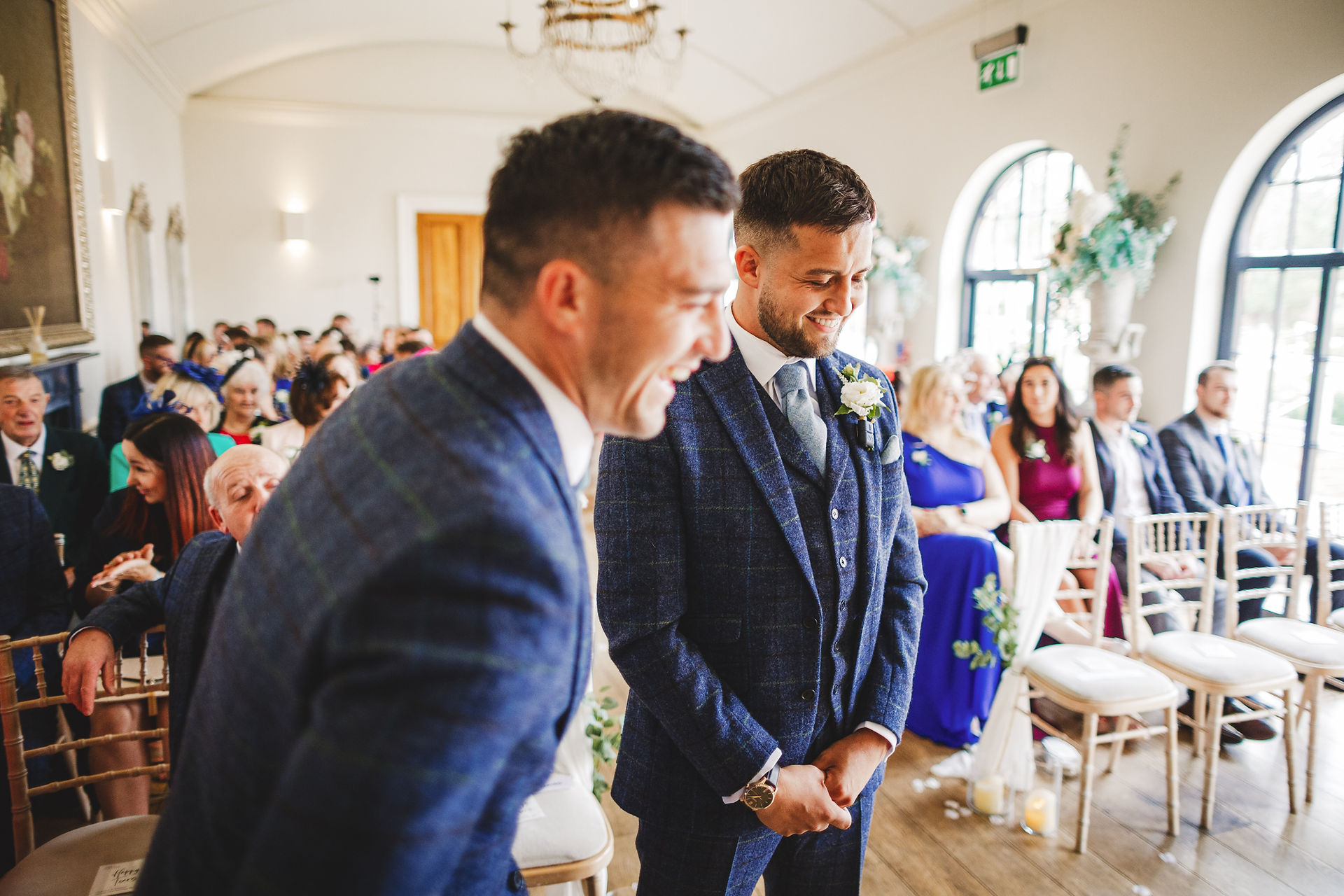 Two men laughing in a wedding, formal attire, guests, Craig Hickey Photo