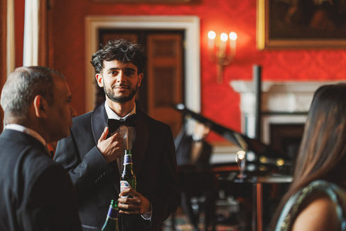 Man in a tuxedo holding beer, at a formal event. Craig Hickey Photo
