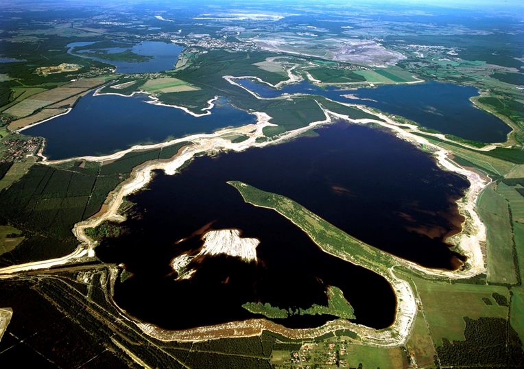 Pictured: Artificial lakes and natural habitats in former East Germany formed from flooding surface mines. Reunification led to massive economic upheaval in former East Germany, which relied on resource extraction and manufacturing for a lot of its economic output. With reunification, most of these mines and factories were privatised and closed as they were uncompetitive. This led to an economic downturn across the east albeit not as severe as the downturn in neighbouring former Eastern Bloc countries, such as Poland and Czechia.