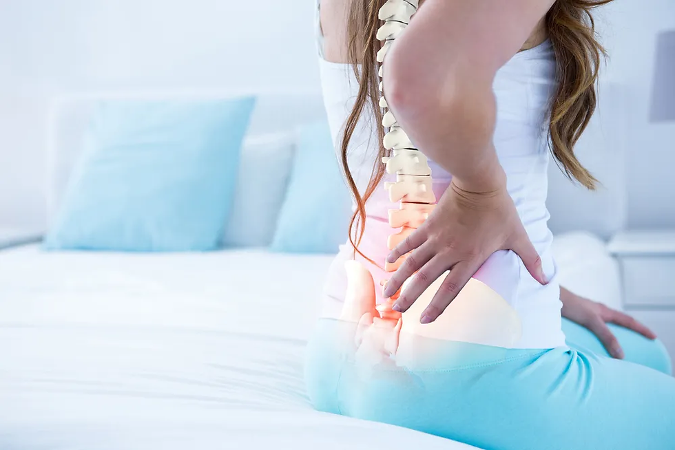 Phụ nữ ngồi trên giường ôm lưng dưới đau, cột sống phát sáng đỏ, phòng ngủ tông trắng xanh.