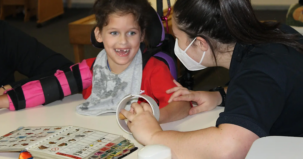 child and speech pathologist using a podd communication during a therapy session at CPEC