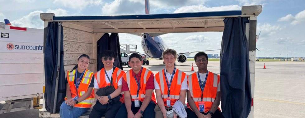 group of smiling people in baggage cart
