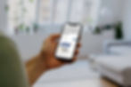 Hand holding a smartphone displaying ATW 2025 Airline Awards announcement. Background shows a bright, modern living room with plants.