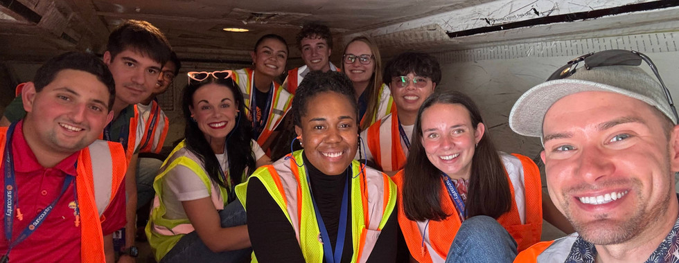 group of people smiling in baggage hold on aircraft