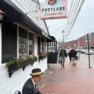 Portland Lobster Co sign with man sitting in front of building