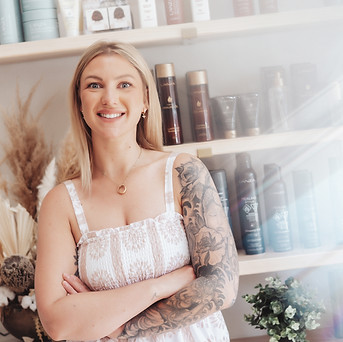 Portrait of Jessi Wallace, a Saskatoon hair stylist at Revamp Salon Company specializing in dimensional blondes, balayage, vivid hair colour, barbering, bridal hair, and hair extensions.