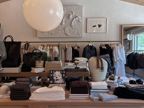 Interior of Buck Mason Nashville featuring neutral clothing displays, wood ceiling, and minimalist retail design