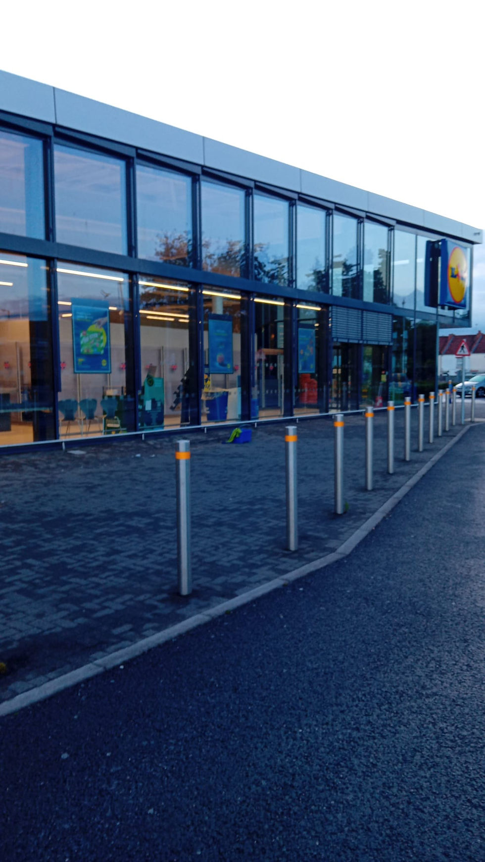 Modern glass storefront of a Lidl grocery store.