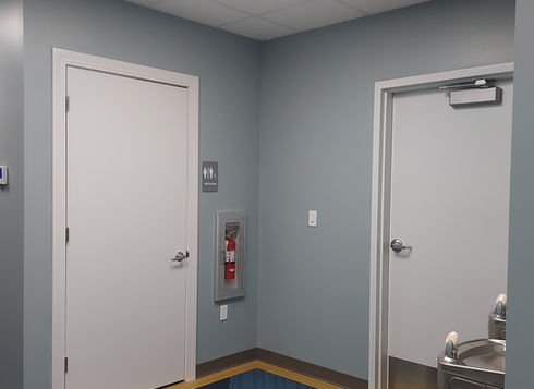 Hallway with two white doors and water fountain