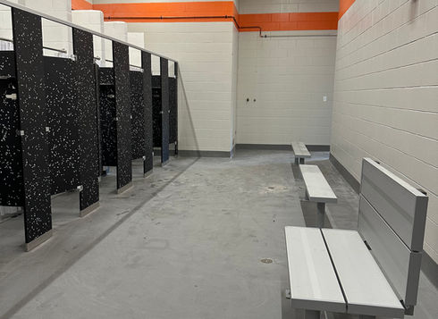 K-12 school locker room with changing stalls and benches