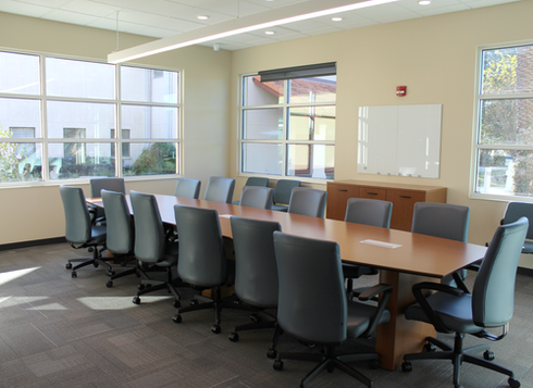 Meeting room with long table, chairs, and windows