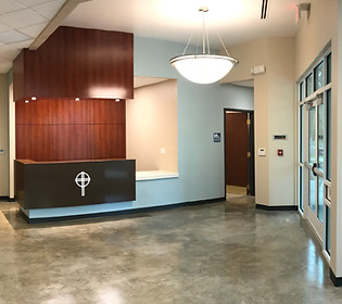 Queen of Peace Catholic Church Administrative building entry lobby with natural lighting and a reception desk with a cross 