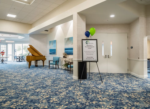 Lobby with grand piano, sign, and balloons