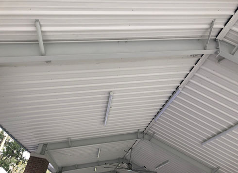 Underside of a corrugated metal roof with support beams