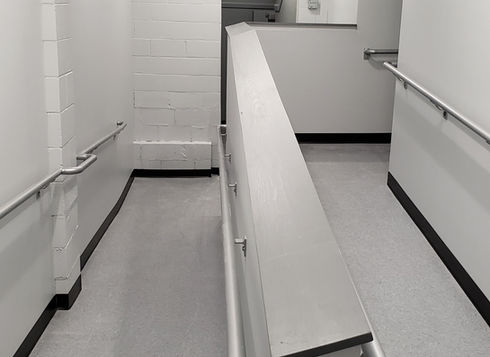 Accessible backstage equipment ramp in a hallway with handrails