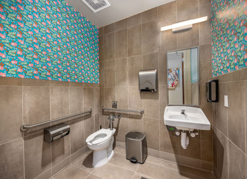 Accessible commercial restroom with grab bars, toilet, and sink
