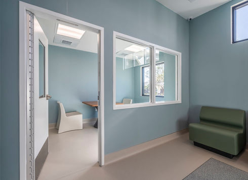 Empty healthcare waiting room with a green anti-ligature bench