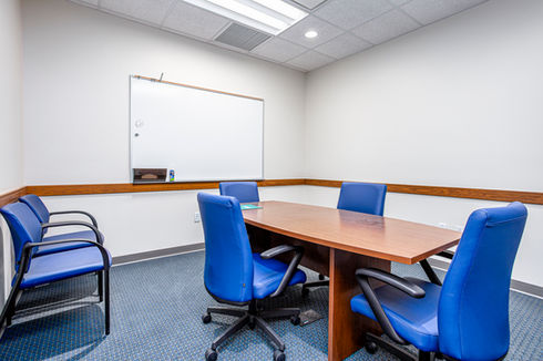Small meeting room with table, chairs, whiteboard
