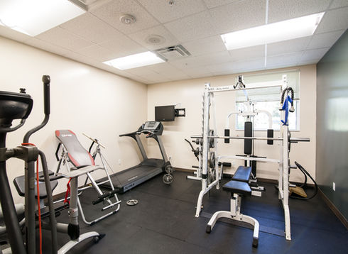 Fitness room with treadmill, elliptical, and weights