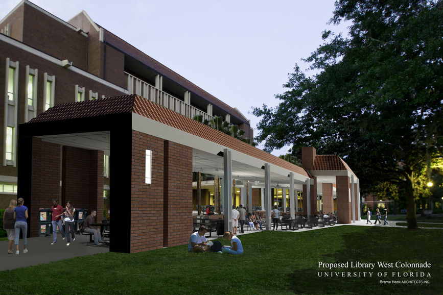 Western view of brick library with brick colonnade showing tables and grass with students walking and studying