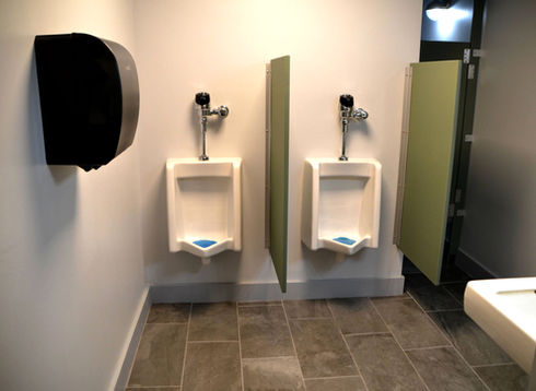 Men's restroom with two urinals and stall partitions