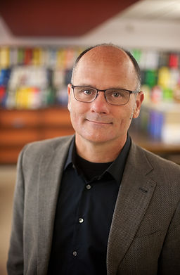 Man with glasses, black shirt and blazer