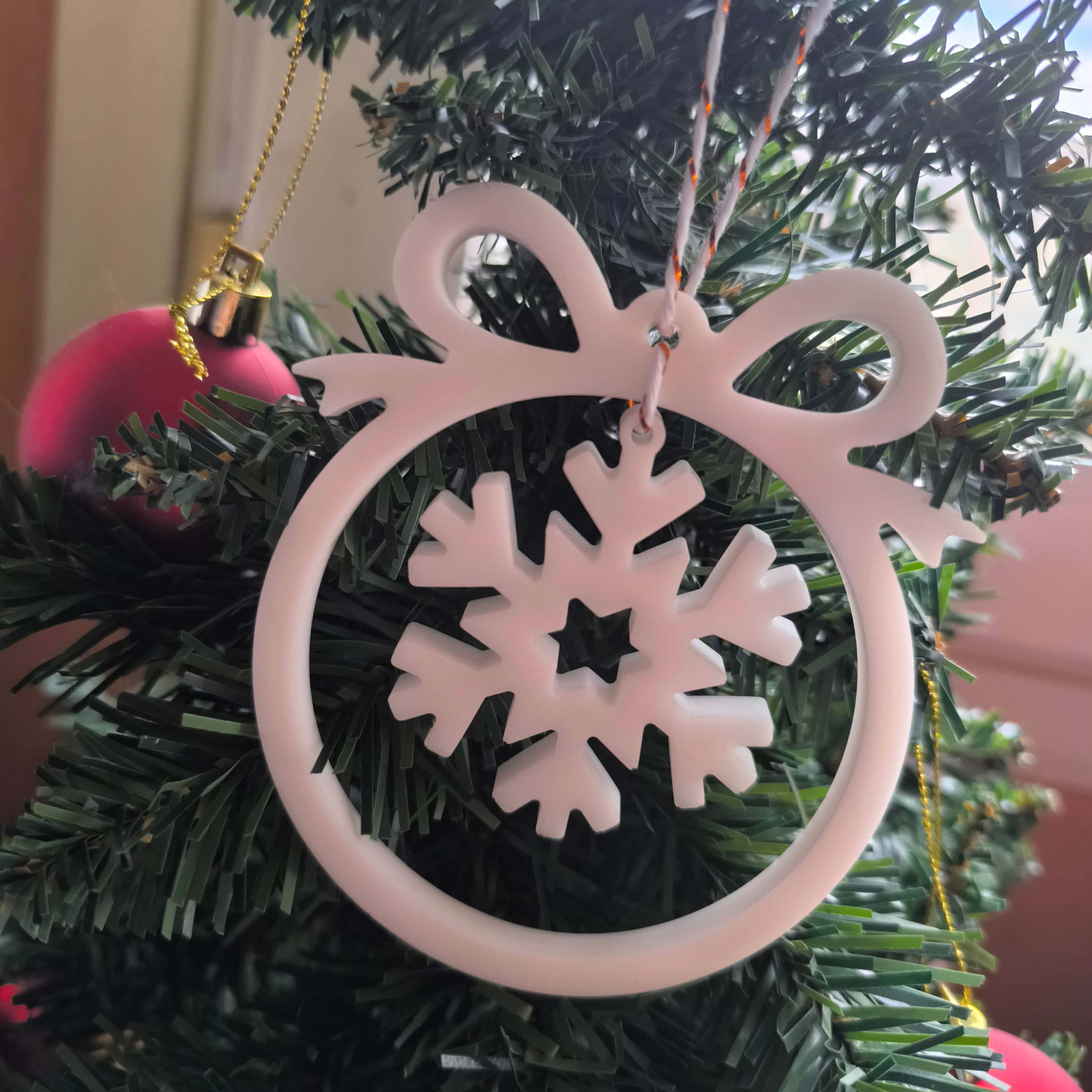 Ornement de noël avec nœud et flocon de neige en résine.