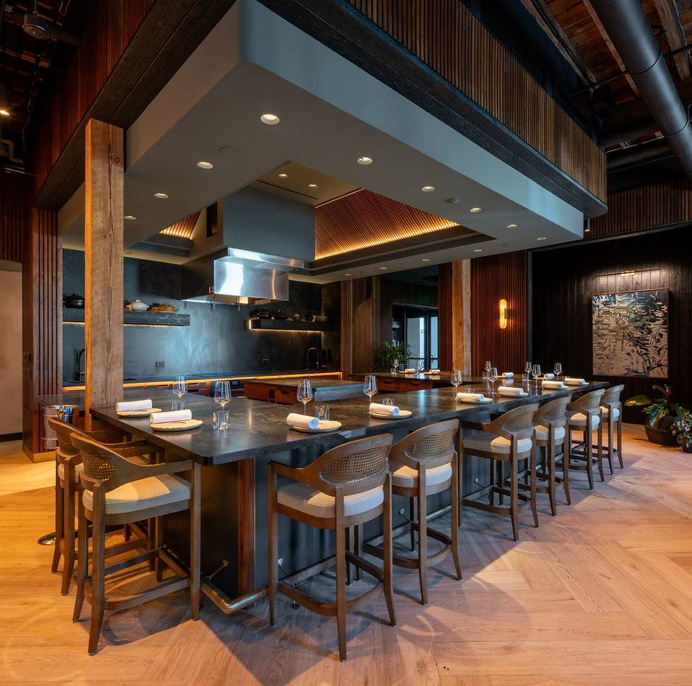Large dining table facing the open kitchen at Emelina. [Photo by Alejandro Chavarria}