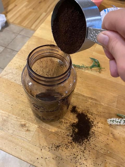 Pour coffee grounds in quart jar