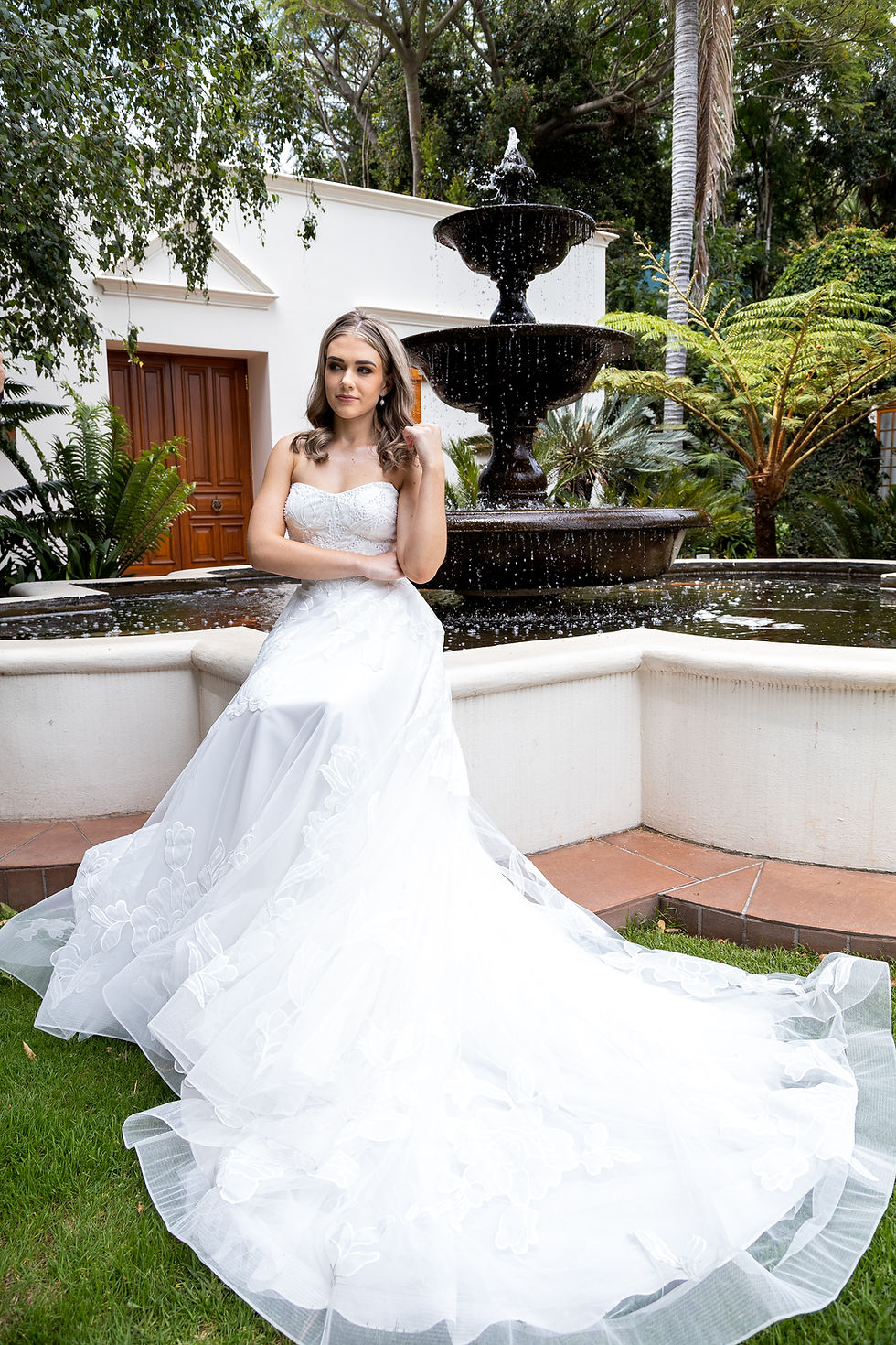 Thumbnail: Strapless lace wedding dress with layered tulle skirt, floral appliqué, and romantic sweeping train.