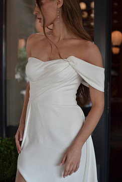 Modern wedding dress with open leg slit, sculpted corset, and buttoned back.