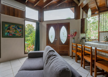 Open living and dining area with sofa and oval windows in Two Bedroom Deluxe Villa at Boutique Hotel Las Cascadas