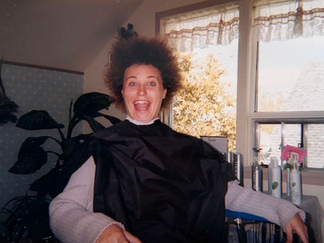 Anita Elliott with wild, dishevelled hair during the removal of braided hair extensions at a hair salon.