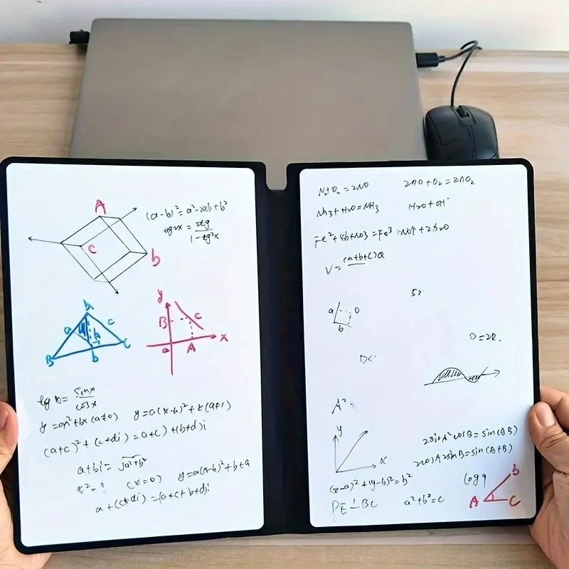 Hands holding a notebook with mathematical equations