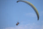 Paragliding pilot and passenger flying high on their tandem paraglider at Kamshet, Maharashtra near Mumbai and Pune.