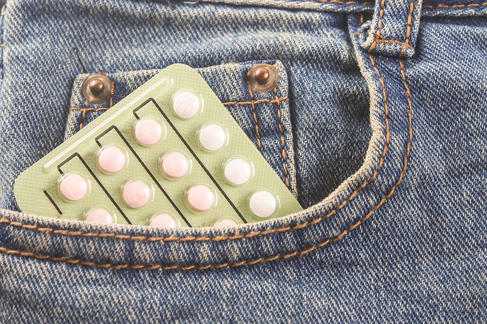 Woman with birth control pills in her jeans pocket