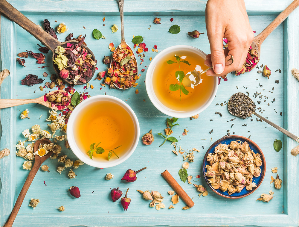 Multiple different teas on a blue serving tray.