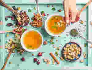 Multiple different teas on a blue serving tray.