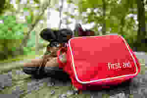 first aid kit next to a pair of hiking boots