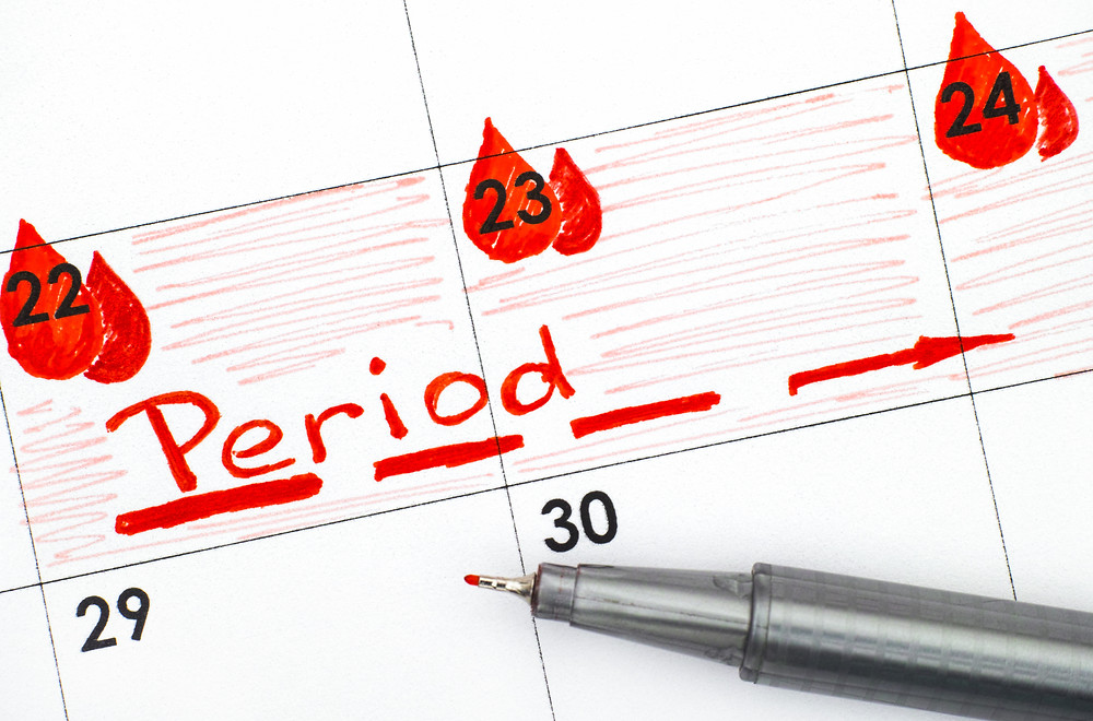 Someone writing down what day they are getting their period.