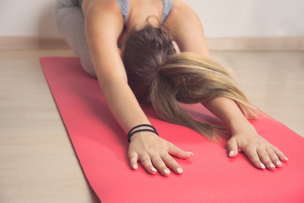 Woman in childs pose to help with PMS