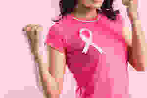 Woman in pink top with breast cancer ribbon