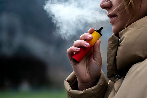 Junge Frau zieht an einer Vape