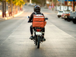 Motorista de servicio delivery recorre las calles de Guatemala para entregar un pedido, representando el crecimiento del comercio digital.