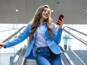 Mujer joven empresaria sonriente utilizando su mobile
