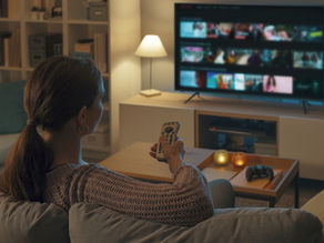 Mujer joven viendo un CTV sus programas favoritos.