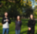 Three smiling colleagues stand outdoors
